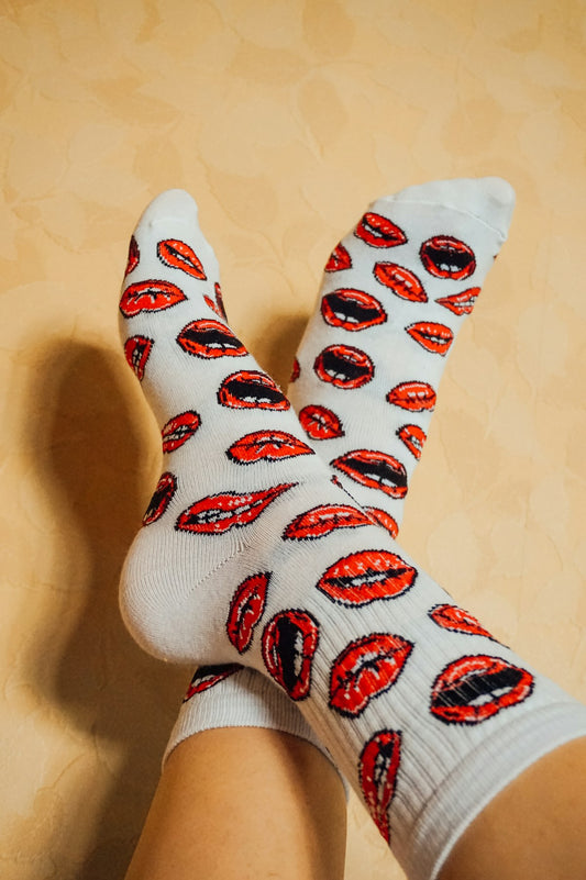 A pair of feet in cozy patterned socks resting comfortably against a warm wall
